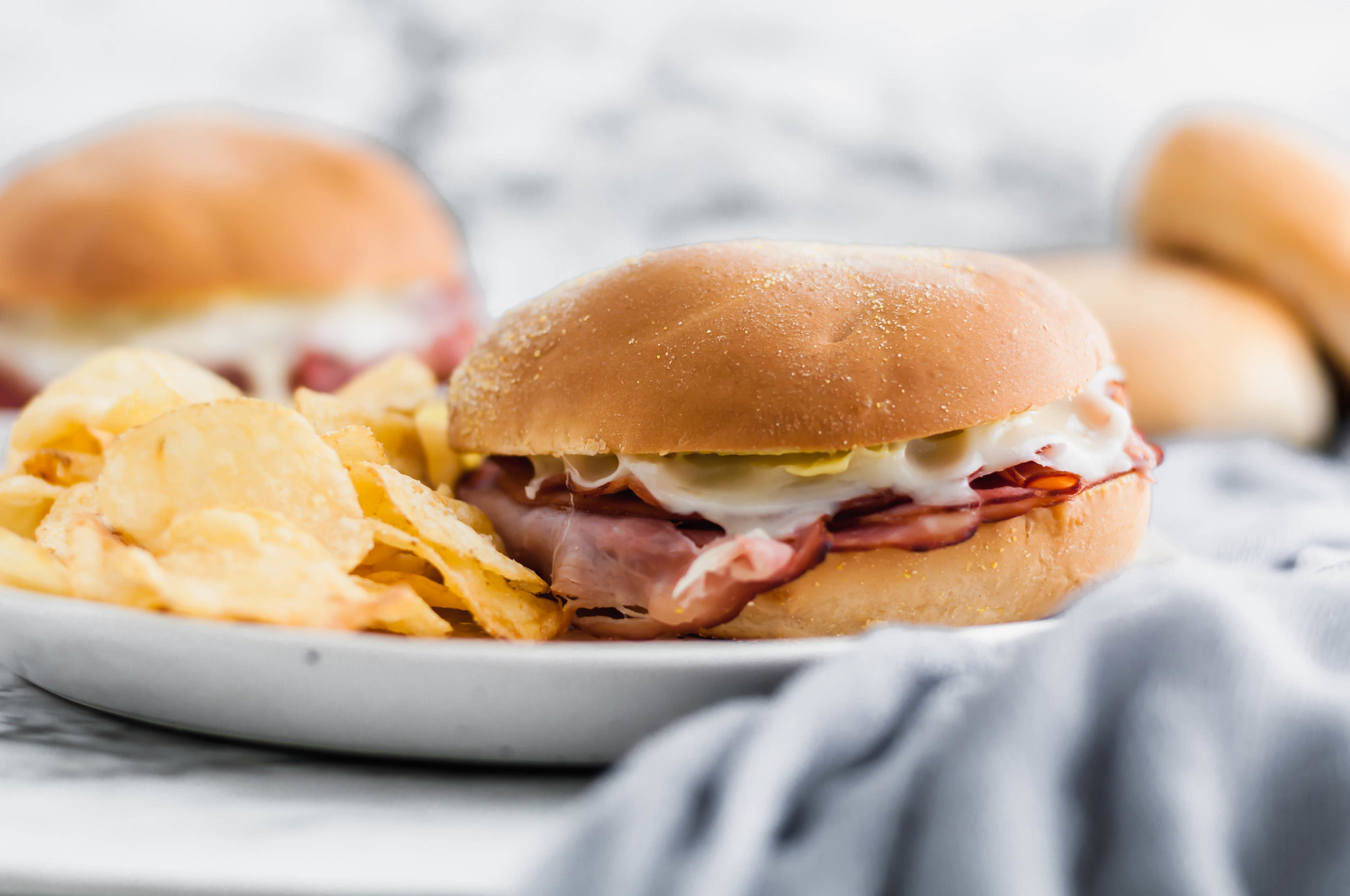 Need an easy lunch or weeknight meal? These Hot Ham and Cheese Sandwiches are the perfect solution. Shaved deli ham (honey ham is my favorite) with melted swiss cheese and a yummy sauce.