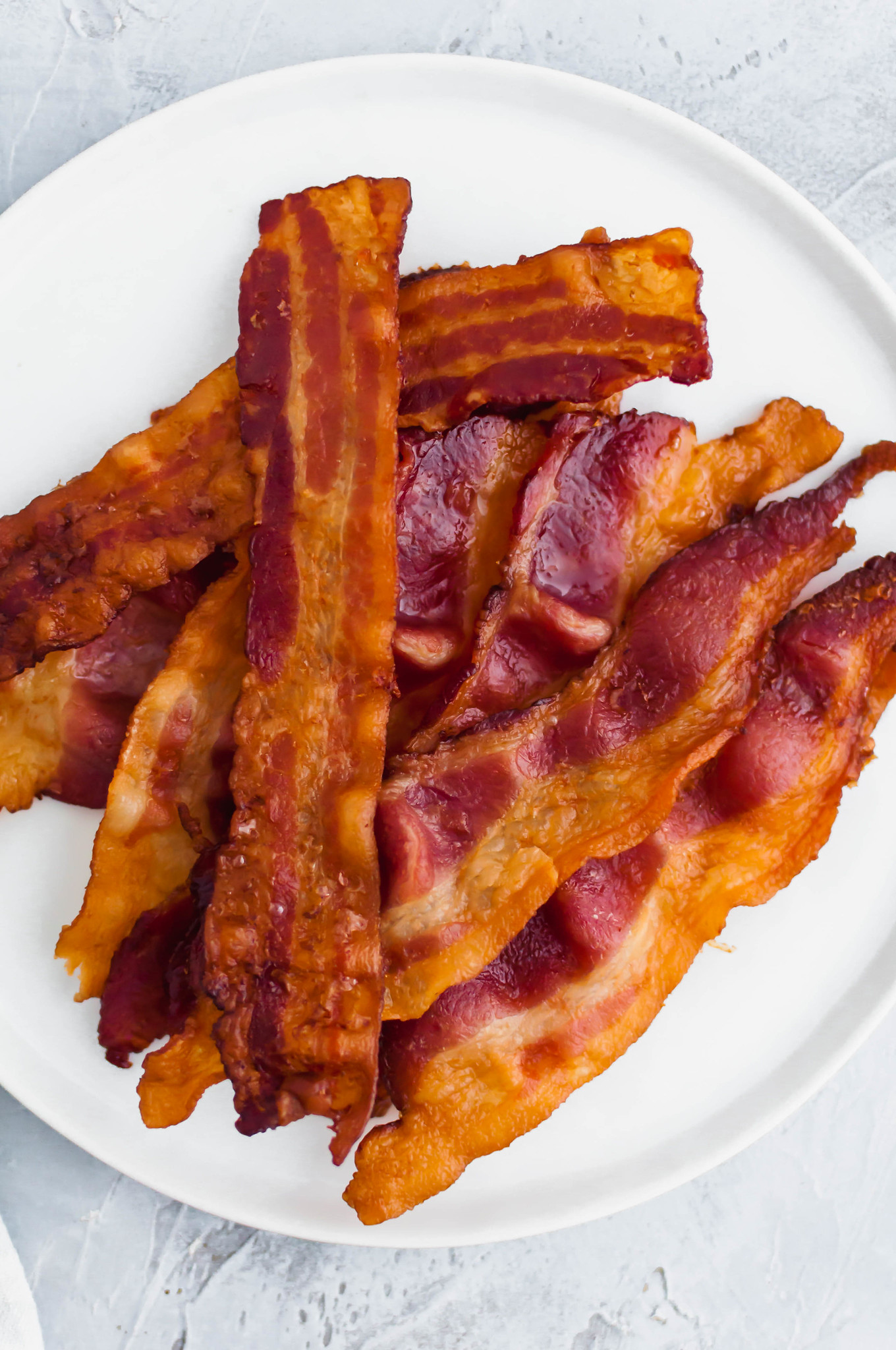Today we're going to talk about How to Bake Bacon. It's the easiest and least messy way to prepare bacon and therefore my favorite. Read on for tips and tricks for the perfect way to prepare bacon.