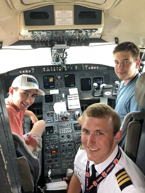 Auburn alum Riley Smith with students in a cockpit.