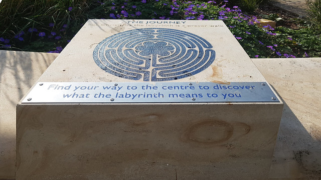 A limestone block outside Gloucester Cathedral depicting a labyrinth as a prayer walk.