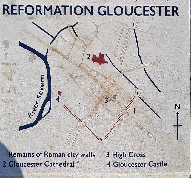 A limestone block outside Gloucester Cathedral depicting Reformation Gloucester.