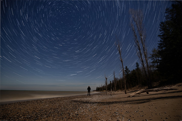 Person watching the stars with star trail effect
