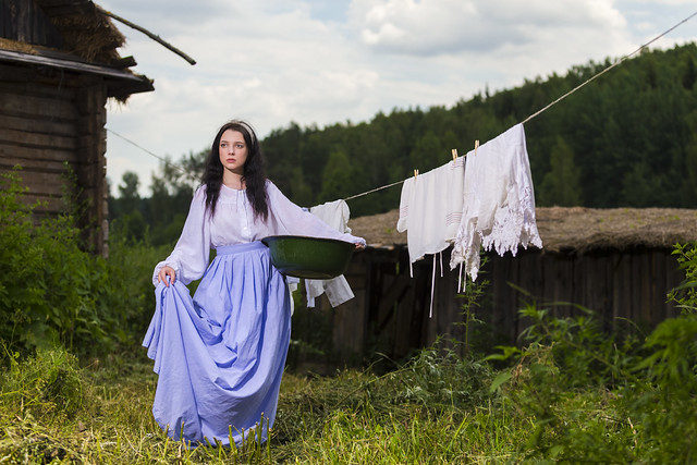 Portrait of Caucasian Brunette Girl in Traditional Rural Dress Holding Basin With Linens in Countryside.