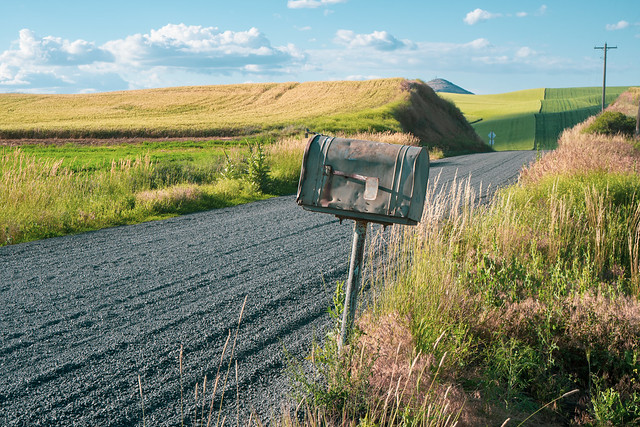 Old rusted abandoned mailbox by the side of a dirt unpaved farm road in the Palouse of Eastern Washington State