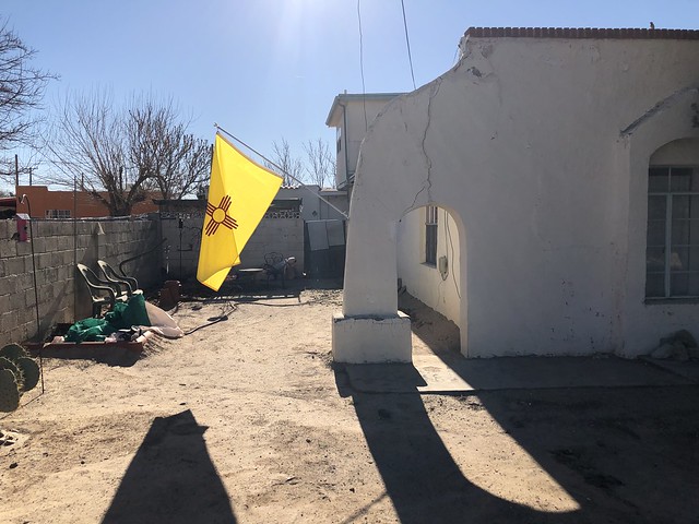 State flag catches the winter sun, side yard on Calle del Norte, Mesilla, New Mexico