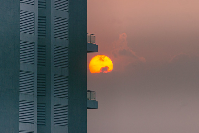 Scyscraper swallowing a setting sun