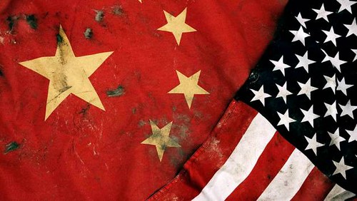 Low key photography of grungy old flags of China and USA.