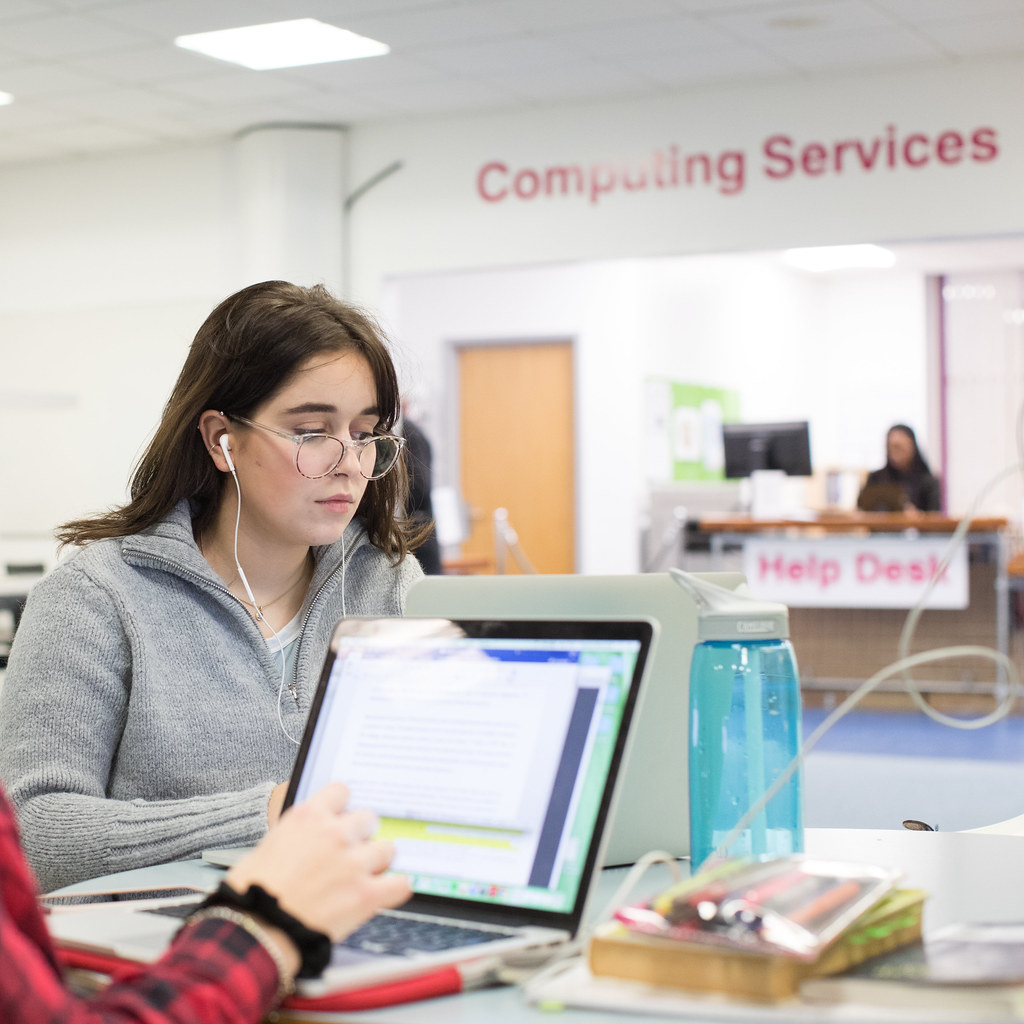 Students working in the Library near the IT help desk.