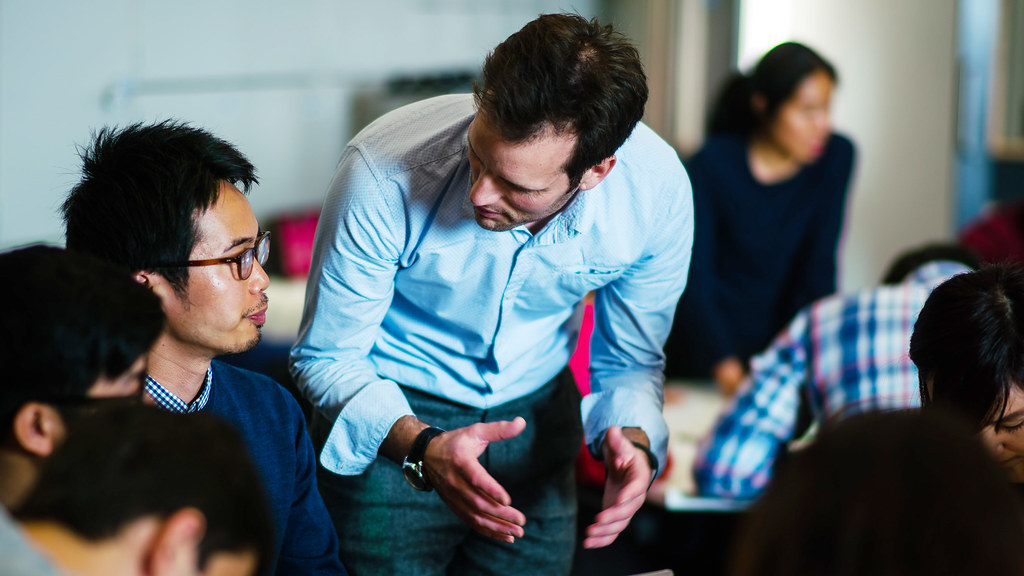 A lecturer talking to a student in a seminar