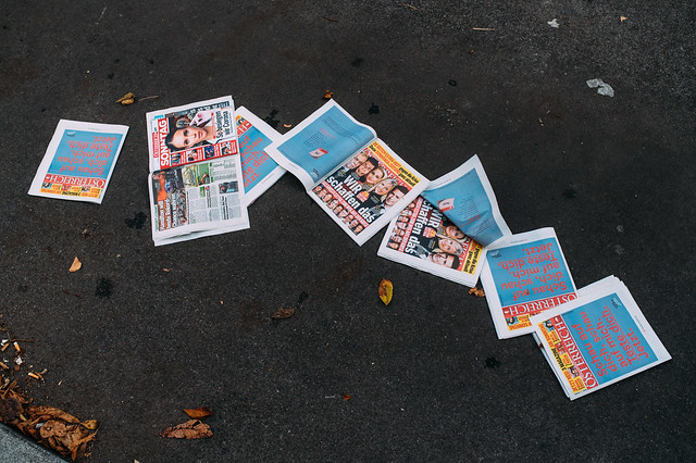 Weggeworfene Zeitungen auf dem Asphalt