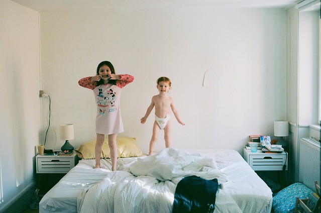 couple babies jumping on the bed