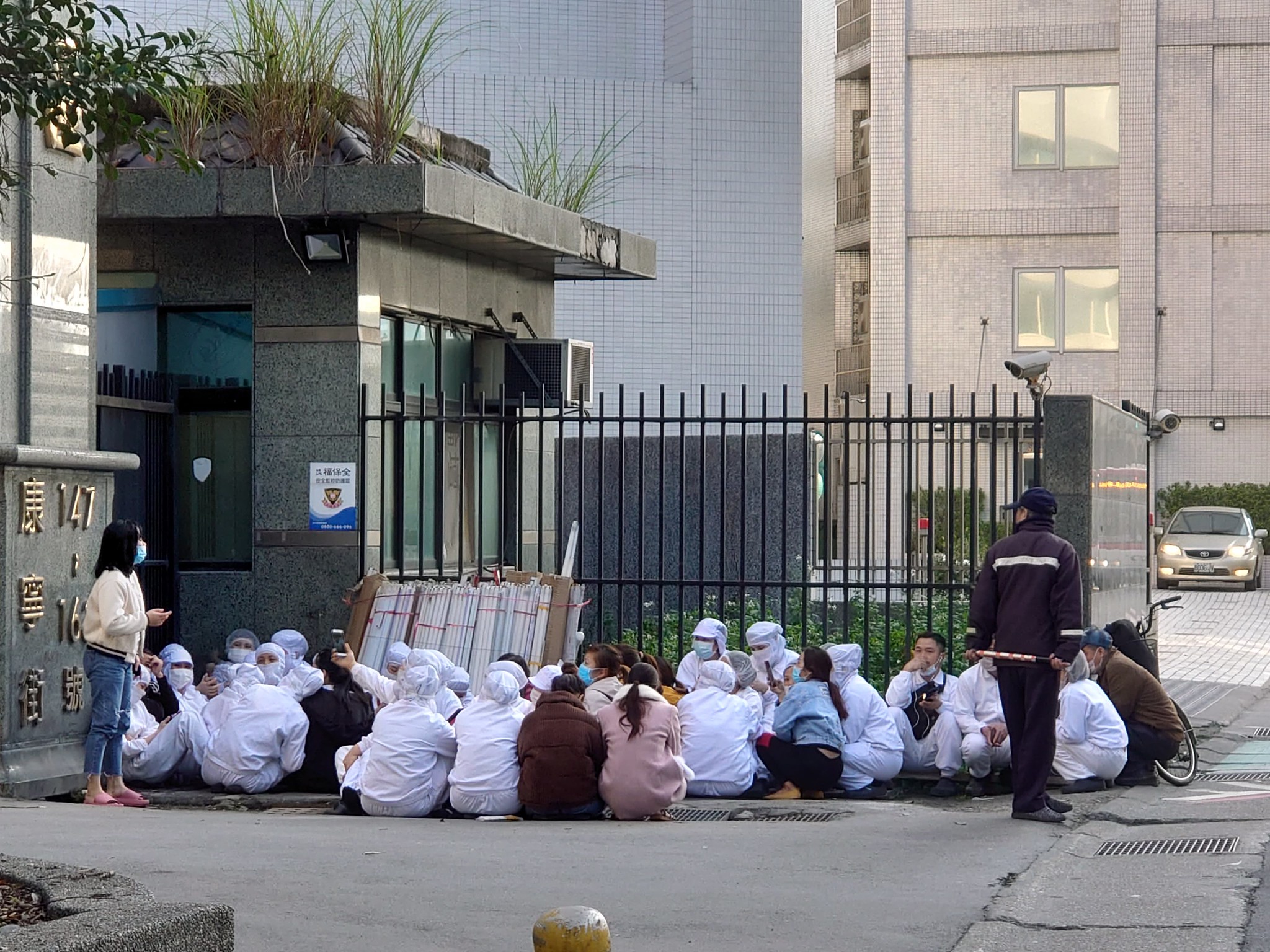 美堤移工聚在工廠門口靜坐抗議。（台灣國際勞工協會提供）