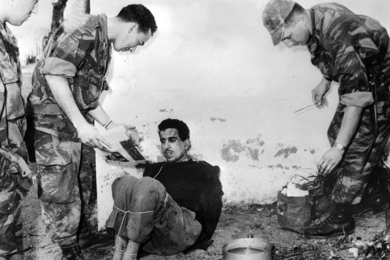 1957年，法國士兵訊問手腳遭綑綁的阿爾及利亞人。（圖片來源：Jacques Grevin/Intercontinentale/AFP）