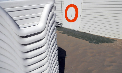 white plastic chairs stacked up at a beach in Holland