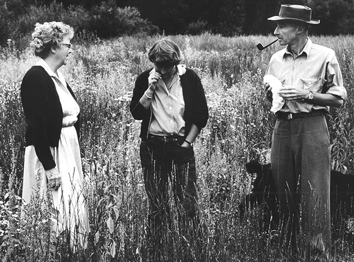 two women and a man in a field