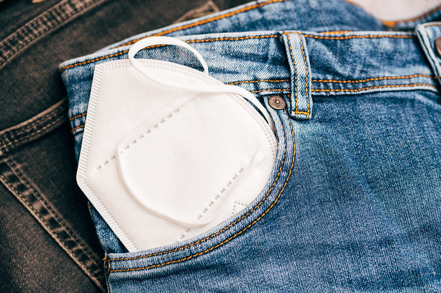 Close-up of a FFP2 face mask in a pocket of blue jeans