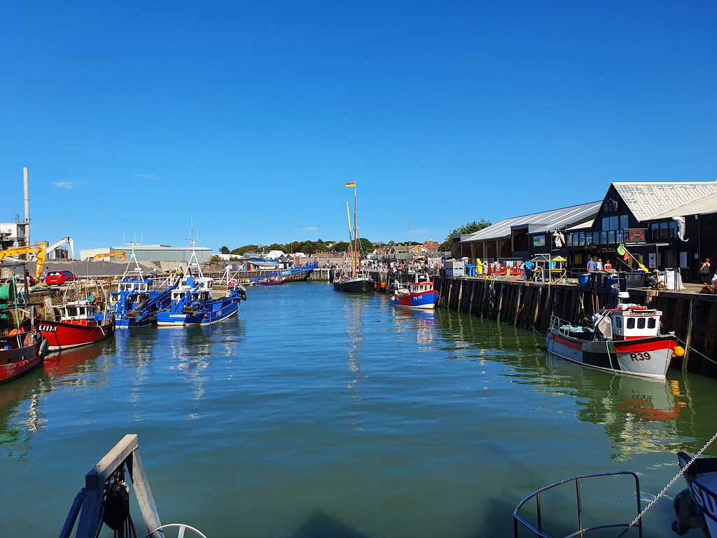 A view of the harbor in Whitstable on a beautiful sunny day, with clear blue sky.