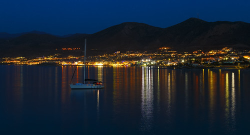 night view of the mountains, city, beach, sea. The reflection of lights in water. Hersonissos Crete Greece