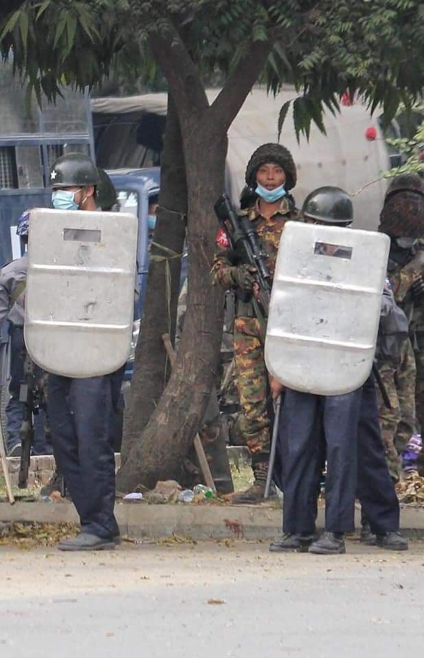 รูปพลแม่นปืนยืนปะปนร่วมกับตำรวจปราบจลาจล เพื่อสลายการชุมนุมที่เขตมหาอ่องเมียะ เมืองมัณฑะเลย์ (ที่มา Khit Thit Media)