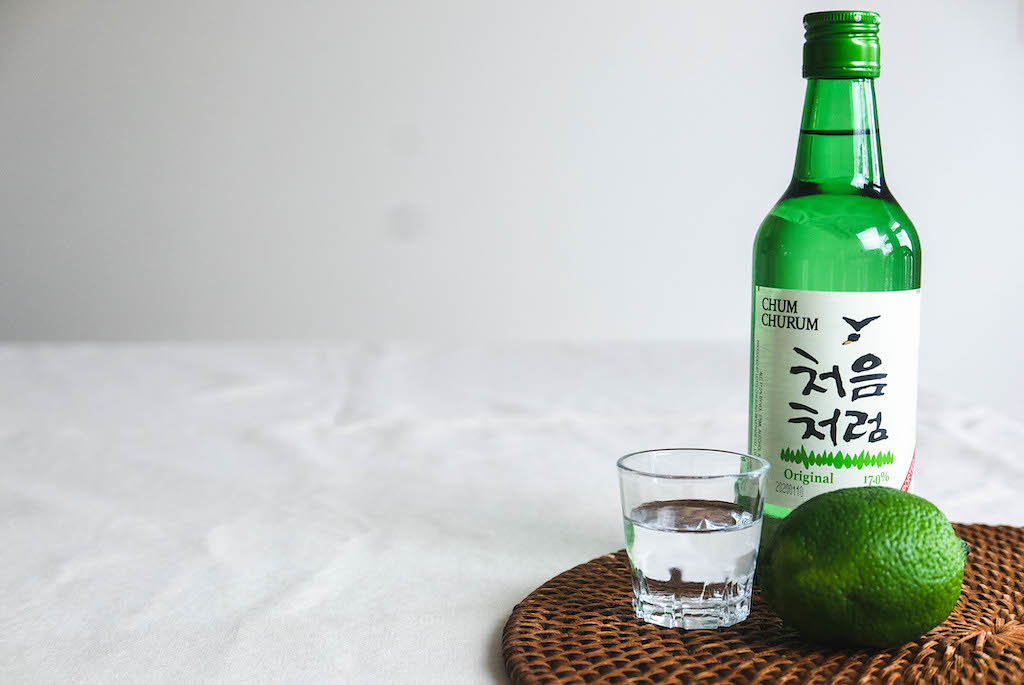 A Bottle of Soju With A Shot Glass and Lime.