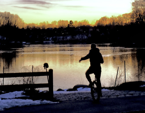 unicycle man balancing silhouette sunset lake water fence oaklandlake alleypondpark queens nyc newyork february172021 goldenhour fujixt4 xf18135mmf3556r shore trees reflaciton winter branches