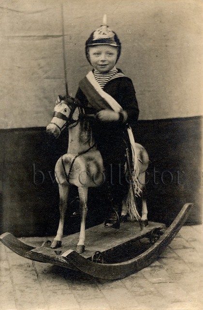 boy with spiked helmet on rocking horse - Junge mit Pickelhaube auf einem Schaukelpferd