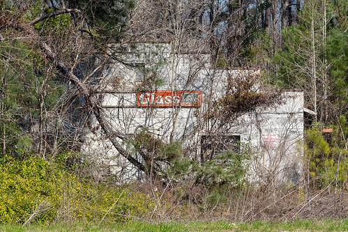 sign building hidden decayed abandoned weeds trees