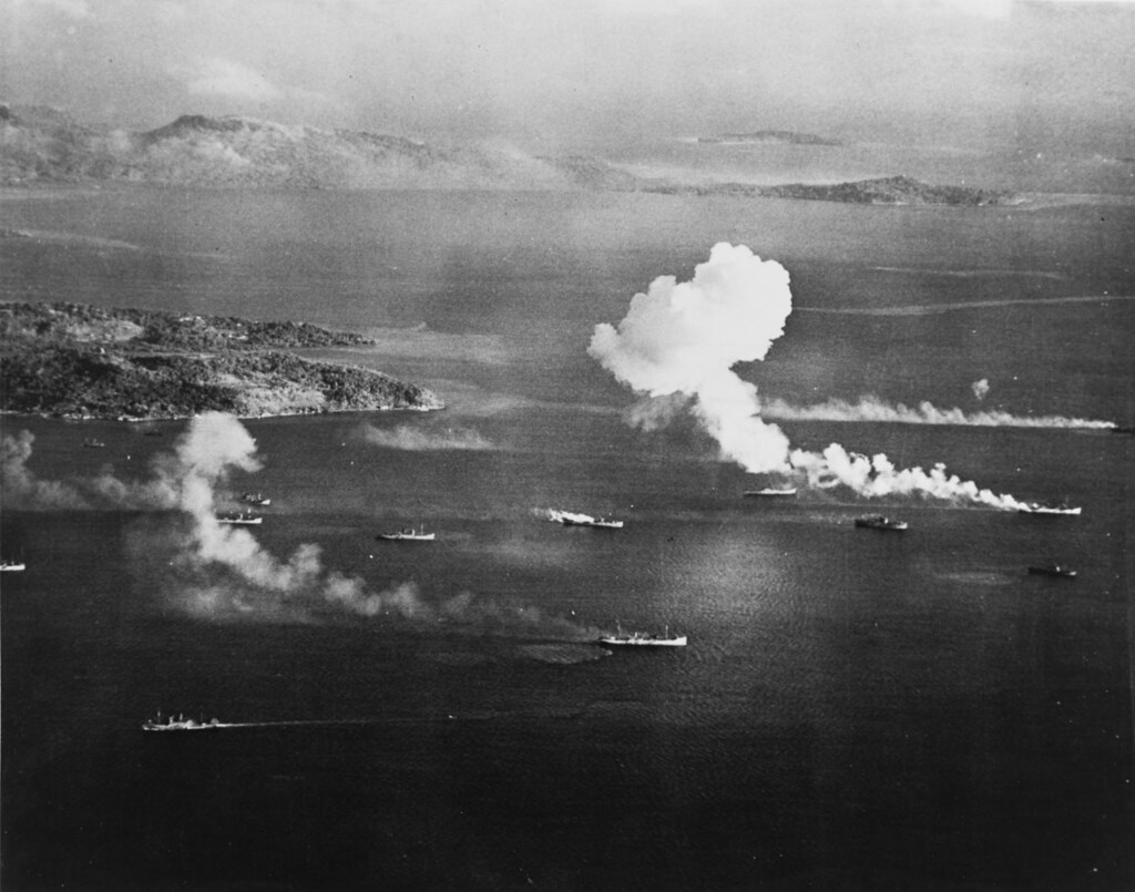 Japanese shipping under air attack, 17 February 1944. Dublon Island is at left, with Moen Island in the background attack in Truuk Lagoon, as seen from an USS INTREPID (CV-11) aircraft on the first d Four of these