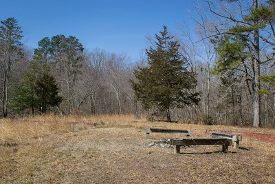 photo of field with benches around a campfire circle
