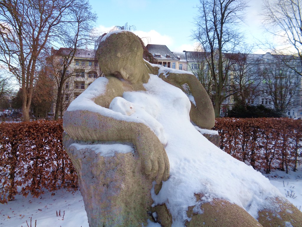 Frau mit Schneekleid und Schneebaby-Statue im Park