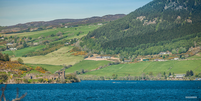 Looking across Loch Ness to Urquhart Castle and some of the dwellings above Urquhart Bay, Inverness-shire, Scotland.