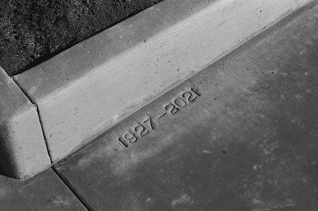 1927-2021. This pavement marking indicates the two times this sidewalk has been paved. NE Hoyt at 62nd, 10 March 2021