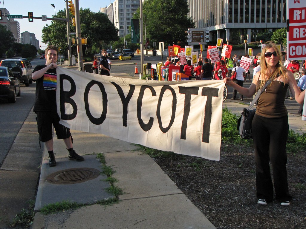 "BOYCOTT" banner at UNITE HERE event Two people hold up a … Flickr