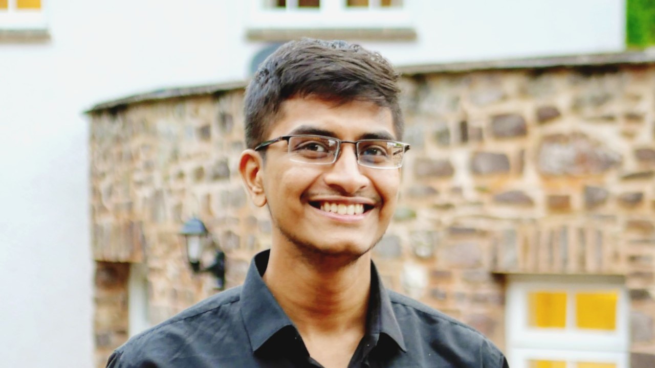 An image of Varun Kumar smiling at camera