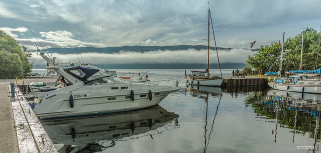 Morning mist still follows the line of Loch Ness at the Marina near Urquhart Castle and Drumnadrochit, Inverness-shire, Scotland.