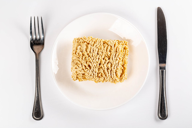 Instant dry noodles on a plate, top view