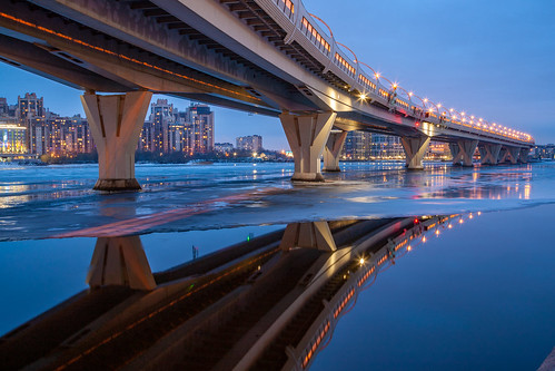 bridge water night evening winter ice river sky clouds architecture building city view