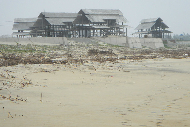 Abandoned shelters on a windy day on the beach in Hoi An, Vietnam