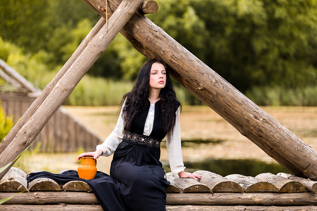 Lovely Sensual Dreaming Caucasian Brunette Female Sitting with Clay Jar On Wooden Bridge  Outdoor.