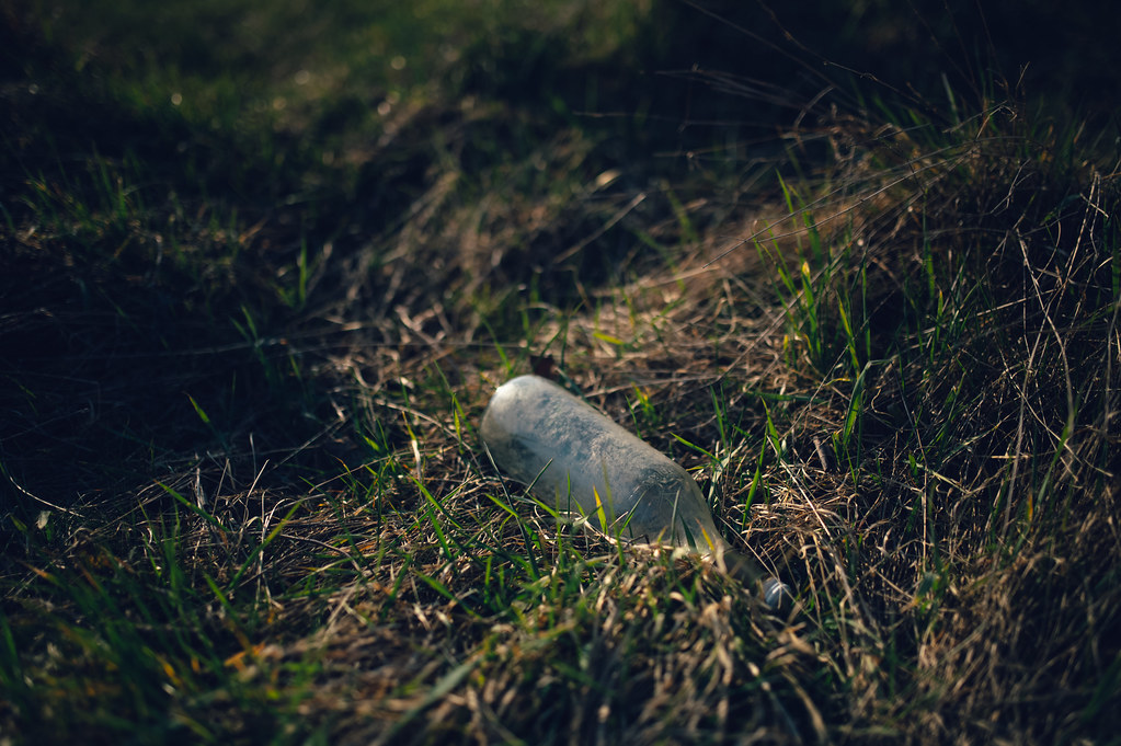 Dusty glass bottle thrown in a field