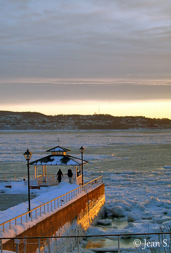 sunset river water people hill ice snow winter light fence clouds sky