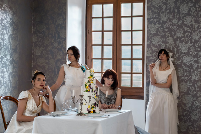 Edito mariage, quatre femmes en robe de mariée autour d'une table, dans un château