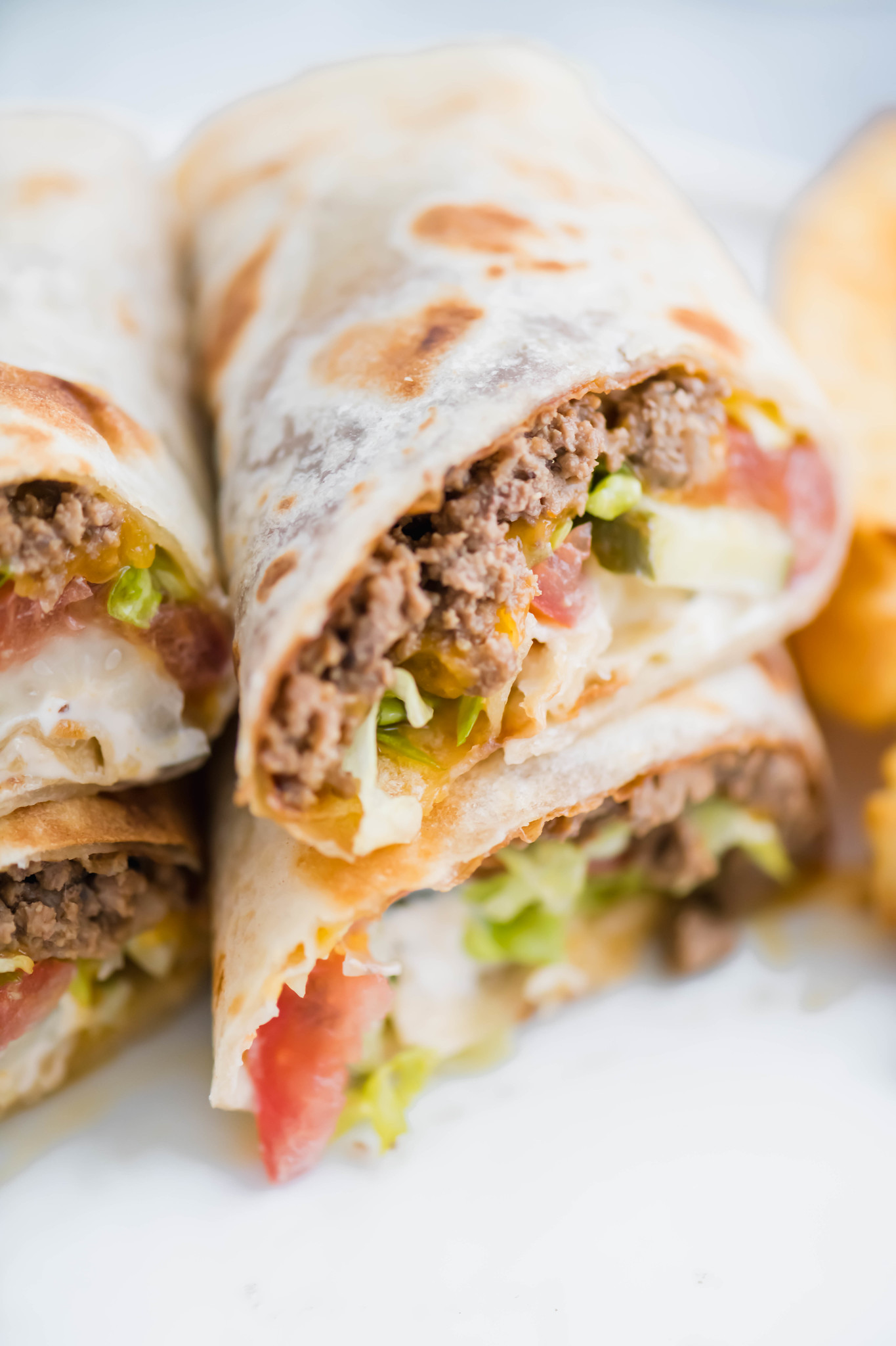 A fun twist on the classic cheeseburger, these Cheeseburger Wraps feature ground beef, cheese, burger sauce, lettuce, tomato and pickles all wrapped up in a flour tortilla.