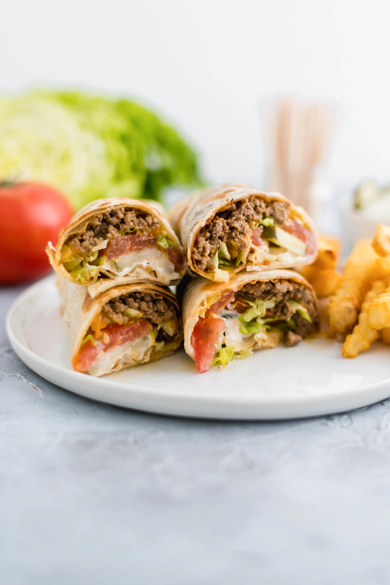 A fun twist on the classic cheeseburger, these Cheeseburger Wraps feature ground beef, cheese, burger sauce, lettuce, tomato and pickles all wrapped up in a flour tortilla.