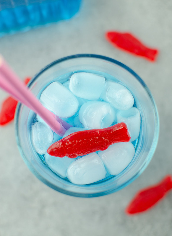 Overhead shot of copycat Sonic Ocean Water; blue soda, ice, and Swedish fish gummy candy in a glass