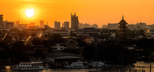 blazing sunset city skyline cityscape riverscape river boats waterway temple pagoda skyscrapers construction outside evening evenings cape bar sky water nature light landscape yellow amber golden orange bangkok thailand