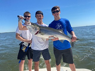 Photo of young men with a large striped bass