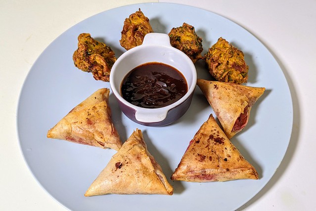 Vegetarian samosas filled with diced beetroot with grated coconut Keralan style. Fritters of kale and sliced onion in chickpeas batter, flavoured with carom seeds and coriander.