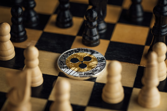 Ripple physical coin surrounded by chess pieces