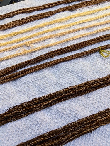 Detail showing close-up of textured handspun cotton by irieknit.  The five skeins of yarn are all wet and lie on a white cotton towel on a patio table outside for drying.